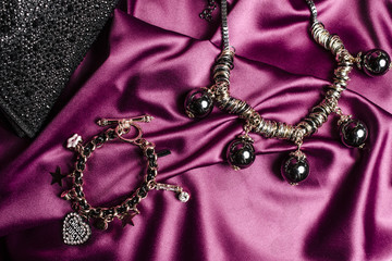 necklace with black beads and bracelet  on silk background
