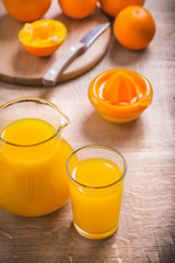 Oranges squeezer knife glass of juice on wooden board