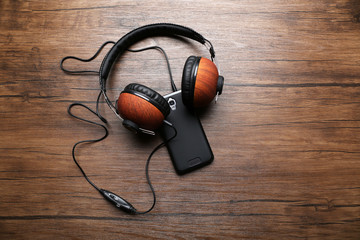 Headphones and smartphone on brown wooden background