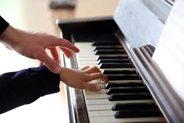 Obraz premium Close up of musician man and girl hands piano playing