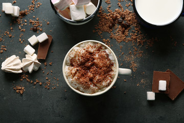 Cup of coffee and sweets on black wooden background