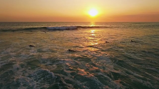 Aerial of a surfer during a beautiful sunset on Bali, Indonesia. This is a slow motion shot (50FPS).