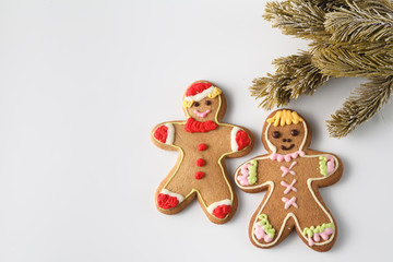 Obraz na płótnie Canvas Two gingerbread men on white with pine