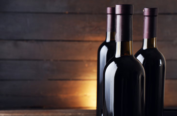 Wine bottles on the table against wooden background