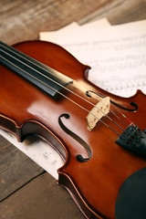 Fototapeta premium Violin and music papers on wooden background