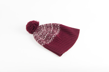 Warm red winter cap with winter pattern and pompon on white back