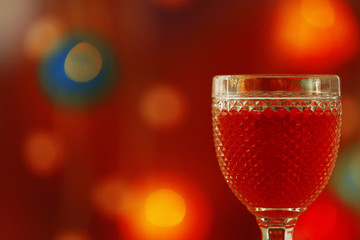 A glass of pink wine on blurred lighted background