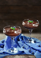 Chocolate dessert in glasses on wooden background