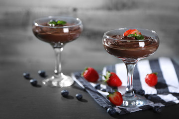 Chocolate mousse with fresh berries on wooden background