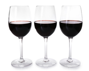Three glasses of red wine on light background