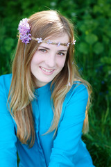 portrait of a beautiful young woman with a wreath in spring park