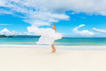 Fototapeta na wymiar Beautiful blond bride in white wedding dress with big long train