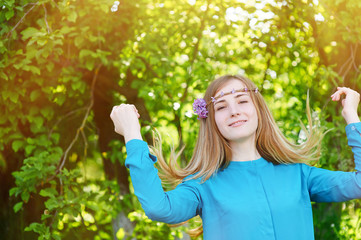 portrait of a beautiful young woman with a wreath in spring park