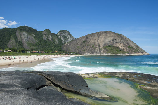Bright view of Itacoatiara Beach from the dramatic rocks of the sea-facing beach in Niteroi, popular with surfers and bodyboarders, in Rio de Janeiro, Brazil 