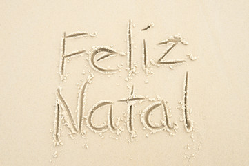 Feliz Natal (Merry Christmas in Portuguese) message handwritten in the sand in Rio de Janeiro,...