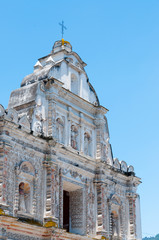 Big White Church With stone Carvings in front of blue sky