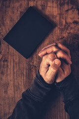 Folded hands of Christian man praying