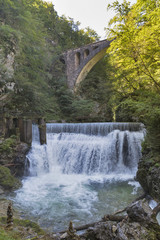 Waterfall beneath stone train bridge in the Vintgar gorge, Slovenia.