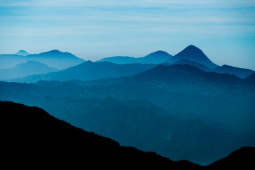 Black Mountain Silhouette in front of Skyscape cold blue mountains with mist and fog close to Quetzaltenango