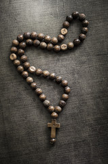 The rosary on old wooden table