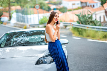 Woman talking phone near the car