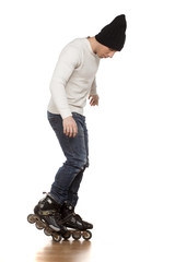 Naklejka premium young handsome man with roller skates posing in the studio