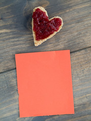Herzförmiges Toast mit Erdbeermarmelade und einem rotem Stück