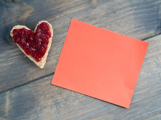 Herzförmiges Toast mit Erdbeermarmelade und einem rotem Stück
