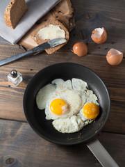 Spiegeleier in einer Pfanne mit Vollkornbrot