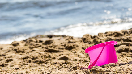 Fototapeta na wymiar Small sand pail toy on summer beach.