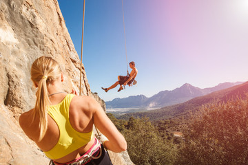 Couple of rock climbers on belay rope