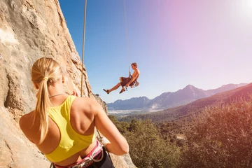 Rolgordijnen Couple of rock climbers on belay rope © serhiipanin