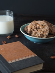 Chocolate Chip Cookies mit einem Glas Milch und einem Notizbuch