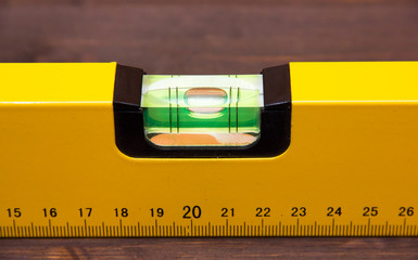 Carpenter's level on wooden table seen from very close