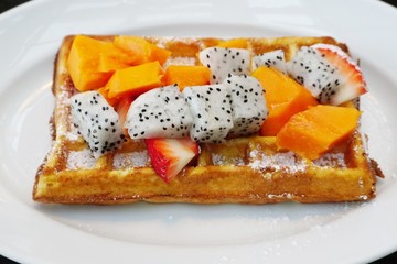 Warm waffles with tropical fruit, fresh mango and dragon fruit