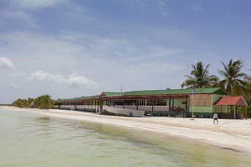 Beautiful beach with palm trees and traditional restaurant and blue sky