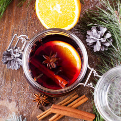 Christmas drink with orange fruit, anise, cinnamon and cloves on wooden table