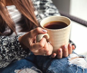 Girl's hands holding a cup of coffee