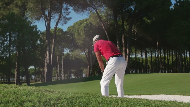 young healthy golfer hitting golf shot with club on course
