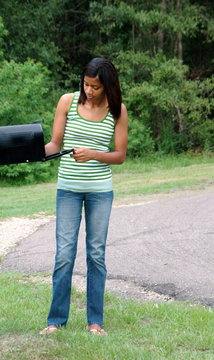 African american female beauty checking her mailbox outside..