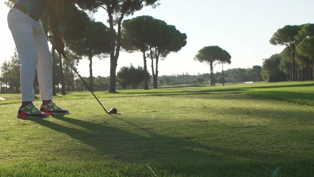 young healthy golfer hitting golf shot with club on course