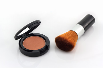 Closeup of face powder and makeup brush.