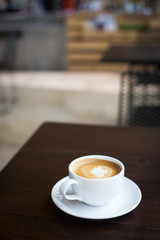Hot art Latte Coffee in a cup on wooden table.