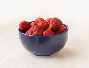 Garden strawberries in dark blue bowls