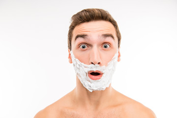 Handsome surprised man with shaving foam on his face