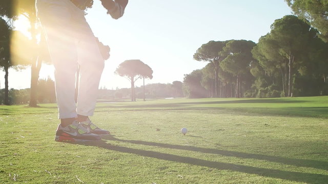 young healthy golfer hitting golf shot with club on course
