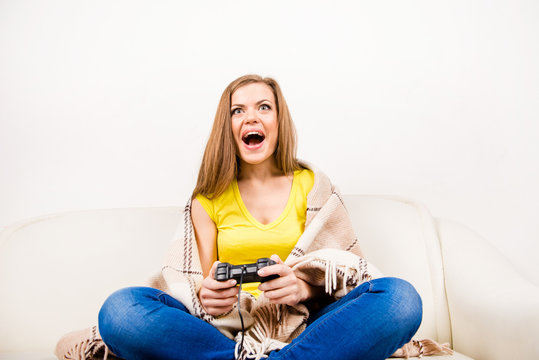 Excited girl playing  with game console on sofa