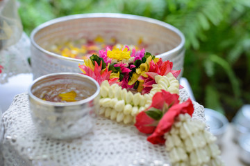 Thai garland Flowers and Water with jasmine and roses corolla in bowl on golden tray (Use for Songkran festival in Thailand)