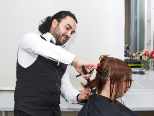 Hairdresser makes hair woman in a beauty salon