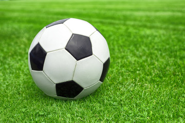Obraz na płótnie Canvas soccer ball on a green lawn close up
